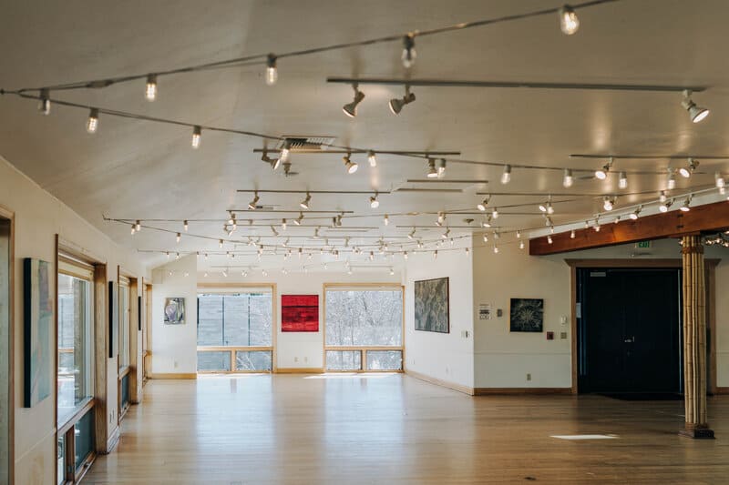 empty room with floor to ceiling windows and string lights at Rembrandt yard in boulder colorado is shown