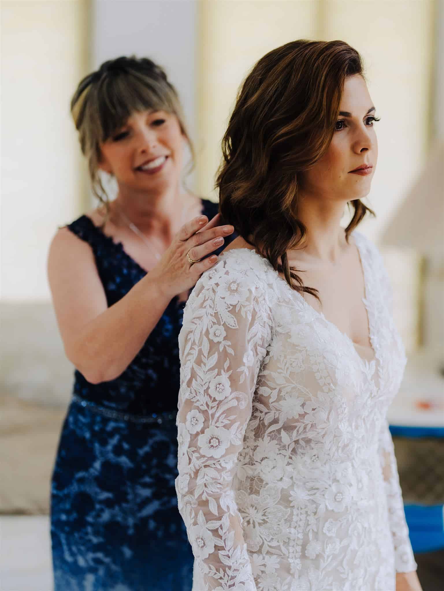 indie bride's mother helping bride put on the dress