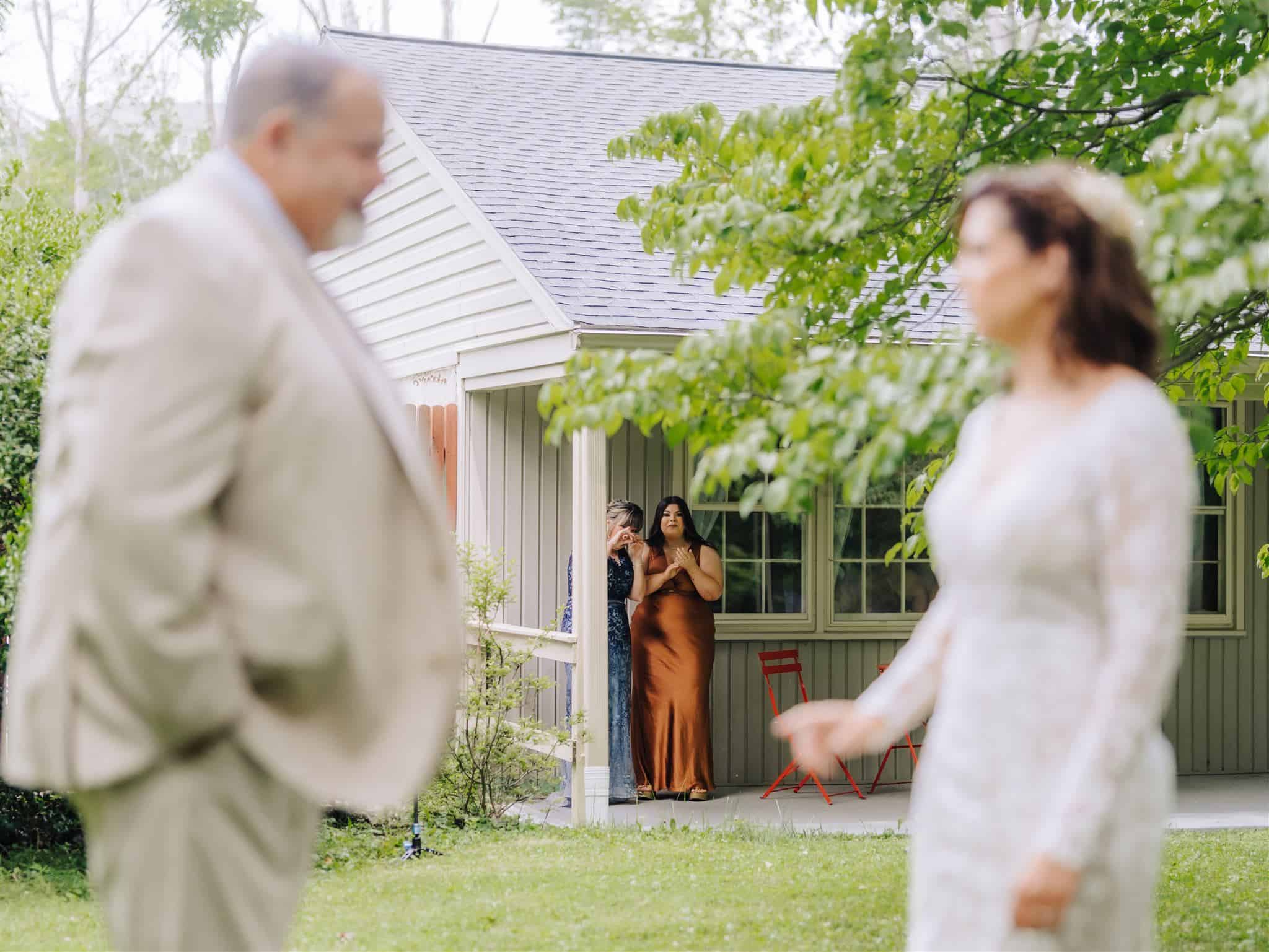 maid of honor and mother watching the first look with father and daughter