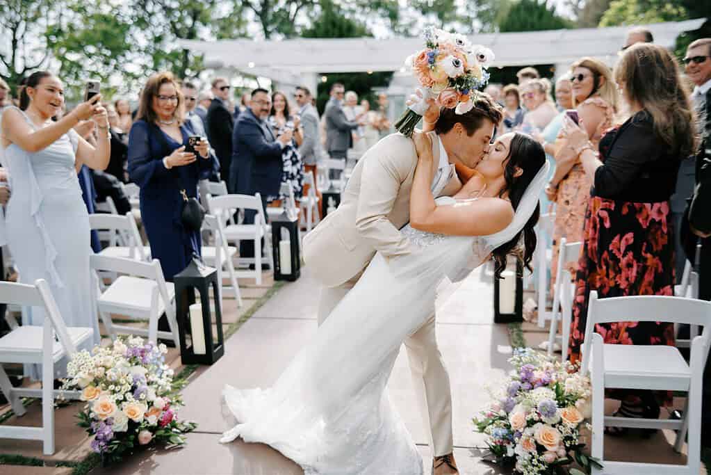 bride and groom dip at the end of the aisle on their wedding day at Lionsgate Event Center