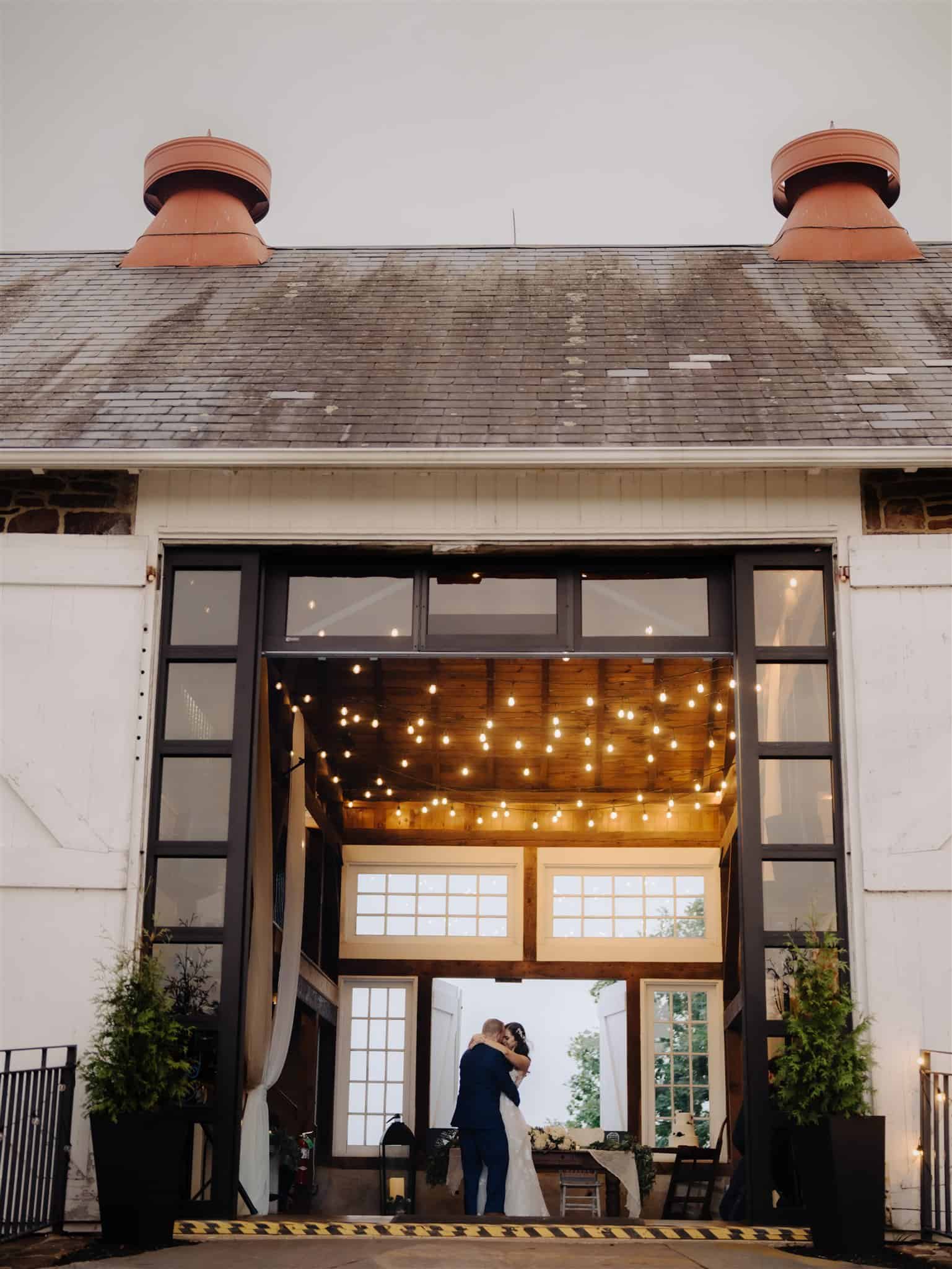 A couple shares a first dance in the barn reception of Durham Hill Farm