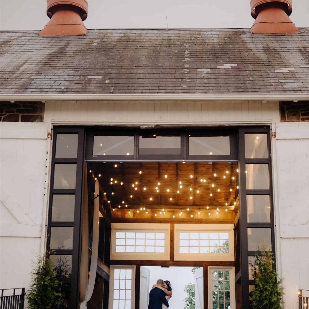 A couple shares a first dance in the barn reception of Durham Hill Farm